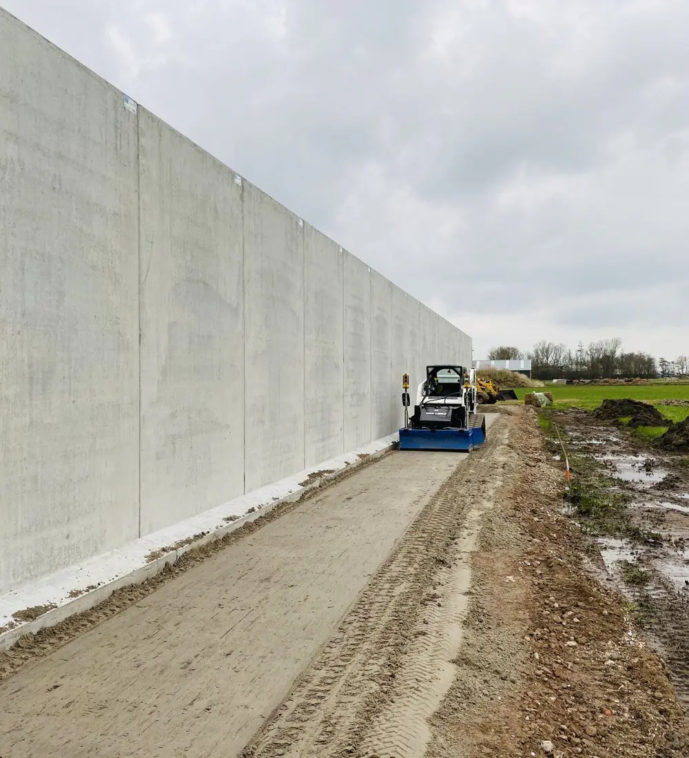 Van Liere Grondwerk profileert een zandbed langs een keerwand